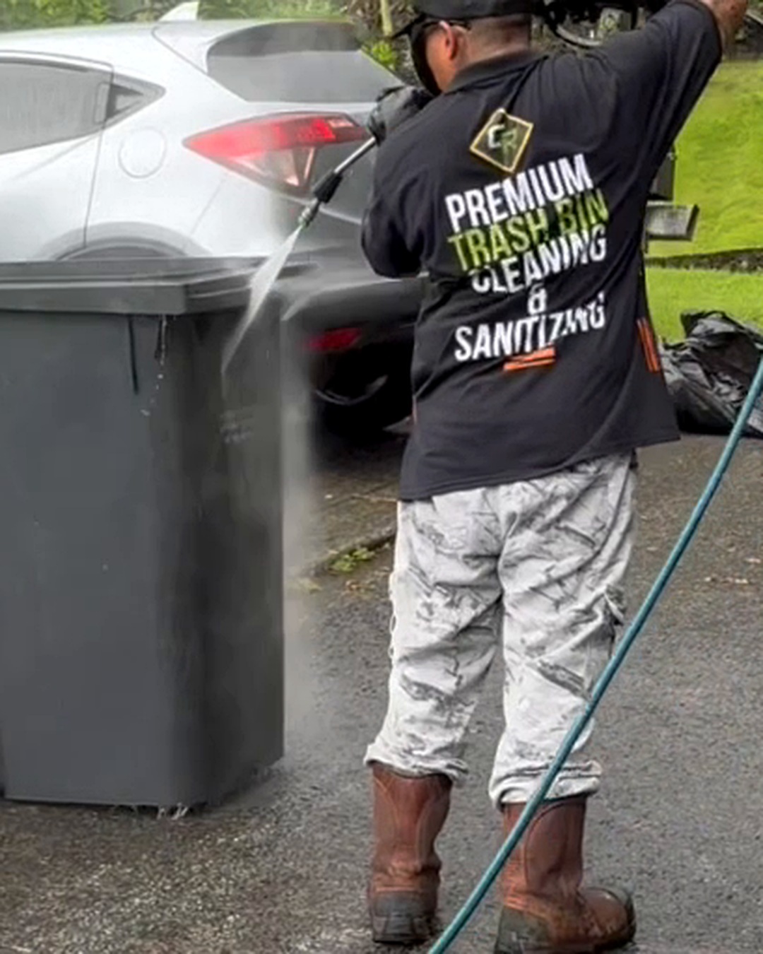 Clean Route Systems technician actively cleaning a residential trash bin